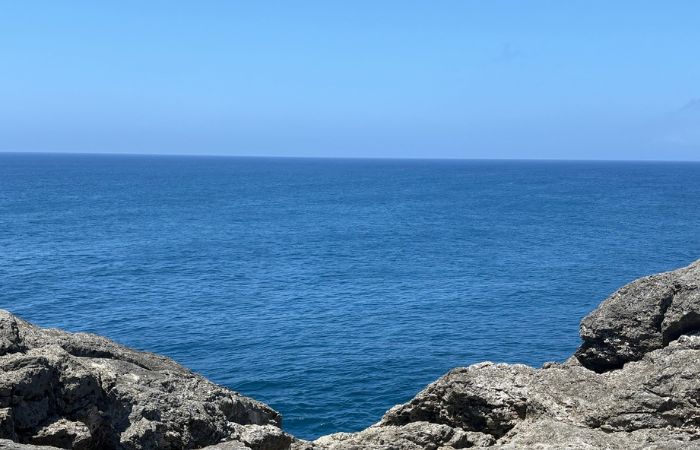 残波岬の岩場から望む青い海と水平線